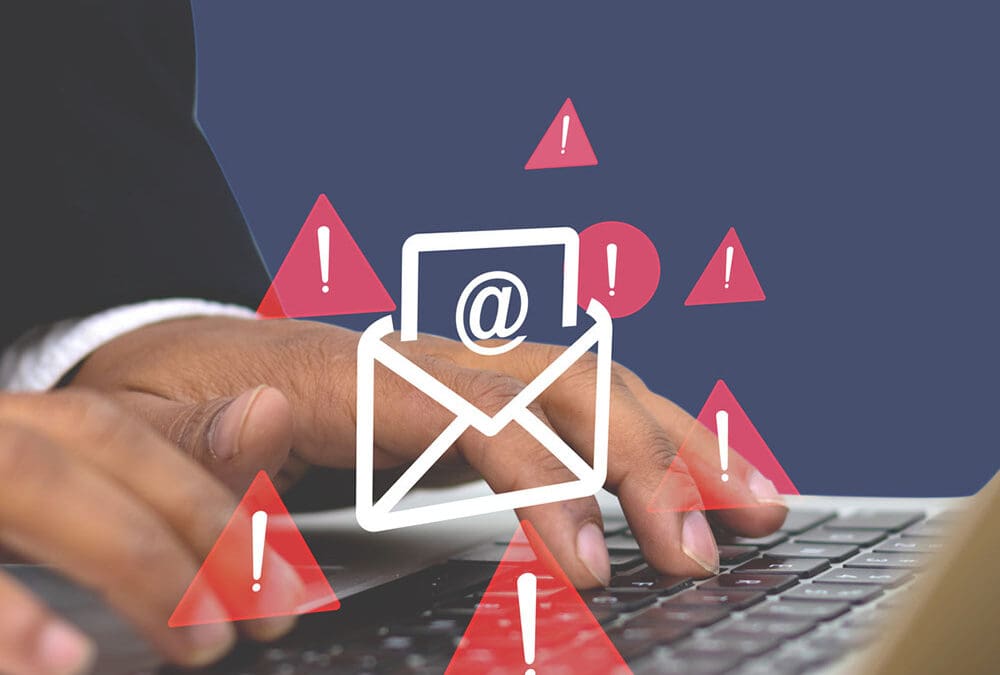 Hands typing on a laptop with email and warning icons overlaid